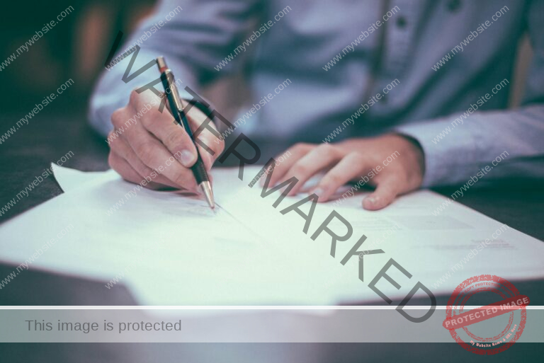 man writing on paper